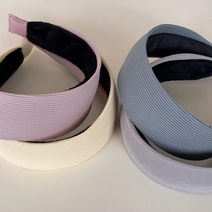 Dettaglio di cerchietti Morandi in tessuto a costine nei colori viola, crema, blu e grigio
