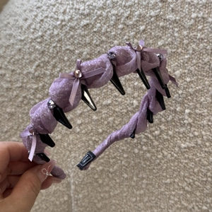 Macro shot of purple headband with crystal bow detail and handmade label texture