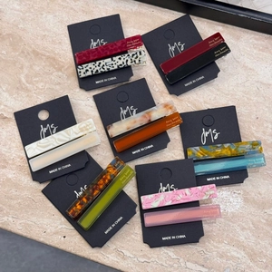 Chic acetate hair clip sets in various colors and patterns on branded cards