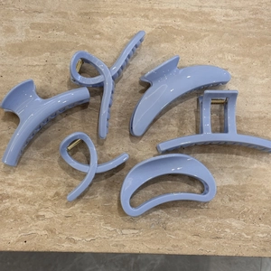 Detailed close-up of a 6-piece light blue hair claw clip set with various trendy shapes