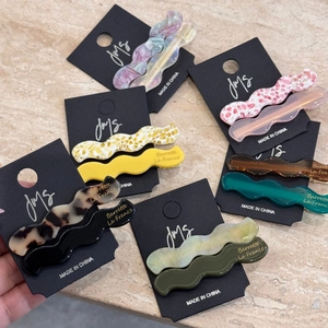 Set of wavy acetate hair clips in multiple colors like tortoiseshell and emerald green