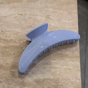 Detailed view of the glossy light blue hair claw clip with sturdy interlocking teeth