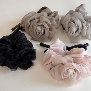 Détail de quatre chouchous roses en tissu transparent noir, marron, gris et rose clair