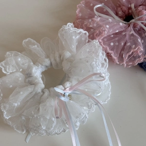 Gros plan détaillé de chouchous en dentelle à pois rose et blanc avec nœuds en satin