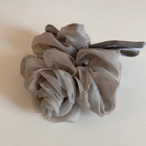 Vue détaillée du chouchou rose en organza gris argenté avec pétales multicouches fins