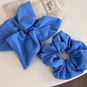Detail view of Klein blue fabric scrunchie set with bow and soft linen texture