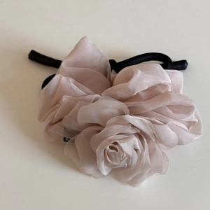 Vue détaillée du chouchou en tissu voilé rose pâle en forme de fleur de rose