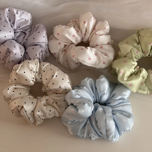 Detailed view of five satin polka dot hair scrunchies on soft white organza background