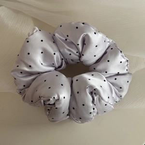 Macro detail of lavender polka dot scrunchie made from shiny satin fabric for hair