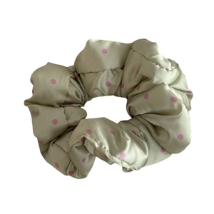 Green satin scrunchie with pink polka dots for stylish hair styling and buns
