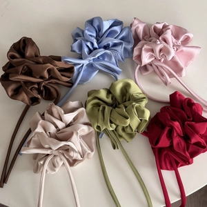 Lot de six chouchous en satin colorés avec de longs rubans élégants sur fond blanc