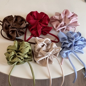 Détail à plat de six chouchous en satin colorés avec de longs rubans en plusieurs nuances