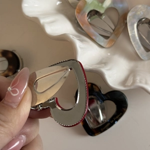 Détail de la pince en métal et du motif de cœur en acétate de cette barrette
