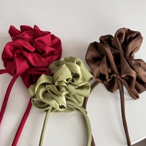 Vue détaillée de trois serre-têtes à fleurs en satin en bordeaux, vert et marron café