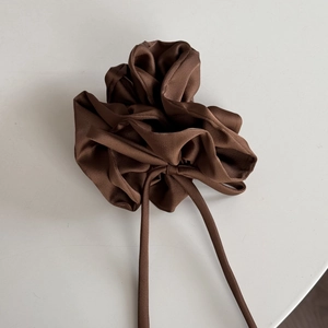 Vue détaillée du chouchou en satin marron avec rubans longs et texture soyeuse