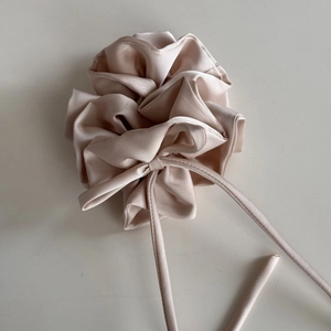 Gros plan sur un chouchou en satin champagne avec une texture élégante en tissu plissé