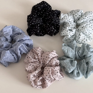 Détail de cinq chouchous à pois en mousseline de couleurs pastel assorties pour femmes