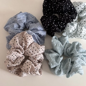 Lot de 5 chouchous à pois aux couleurs pastel sur un fond blanc épuré