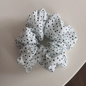 Détail du grand chouchou blanc à pois noirs avec une texture gaufrée élégante
