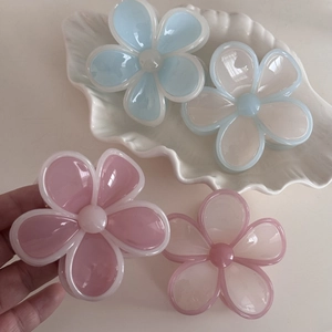Nahaufnahme süßer Haarspangen in Blumenform in Pastellfarben mit glänzendem Finish