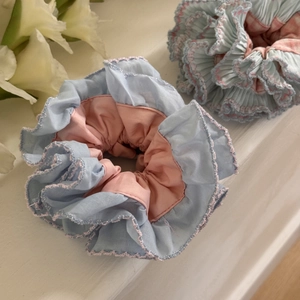 Detail of blue and pink pleated oversized scrunchies with elegant crochet lace edges