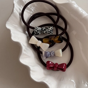 Five-piece set of small acetate bow hair ties in assorted leopard and marble patterns