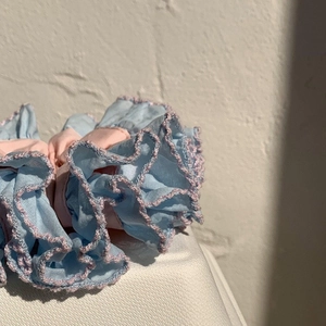 Close-up of blue and pink pleated fabric hair scrunchie with fine stitching details