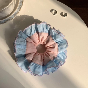 Close-up of pink and blue lace scrunchie fabric texture with soft pleated edges