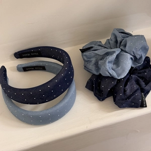 Detail of denim hair accessories set with silver studs and stitched brand labels
