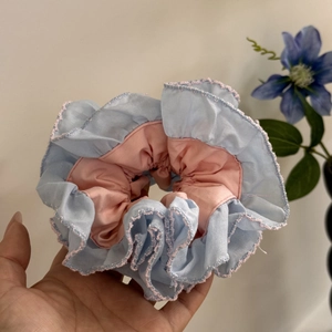Detail of blue and pink pleated scrunchie with lace trim and high elasticity