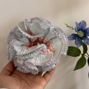 Detail of blue and pink checkered oversized scrunchie with delicate lace wavy edging