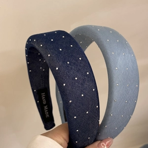 Detail of blue denim scrunchies with glittering rhinestones and a handmade label
