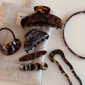 Flat lay of French tortoiseshell acetate hair clips and accessories set on linen