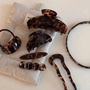 Detail view of tortoiseshell acetate hair clips and accessories set with pearl accents