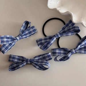 Set of four blue plaid bow hair clips and elastics featuring classic checkered fabric pattern