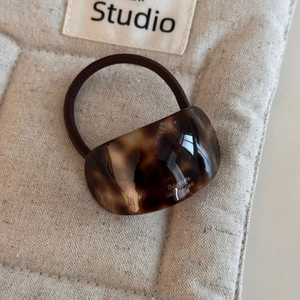 Close-up of caramel pearl acetate hair claw with high-elastic rope and elegant tortoise texture
