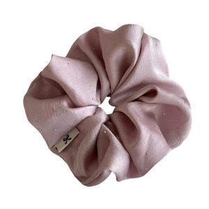 Eleganter hellrosa Satin-Scrunchie mit silbernem Glitzer und einem kleinen Schleifen-Label