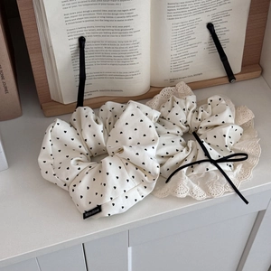 Detailed macro view of cream heart-pattern scrunchies with lace trim and ribbon bows