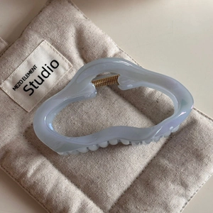 Dettaglio della molletta per capelli marmorizzata azzurra con molla dorata