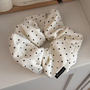 Detail of cream large scrunchie with black heart pattern and Miniline woven label