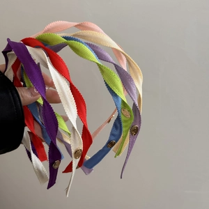 Detail of colorful fabric spiral headbands featuring elegant gold oval metal buckles