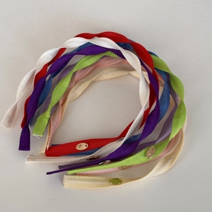 Close-up of colorful ribbed fabric headbands with elegant golden brand metal tags
