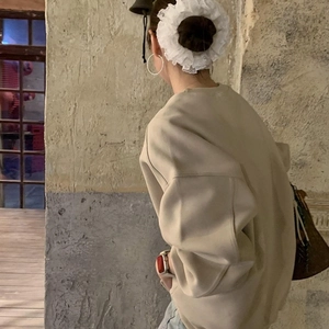 Dettaglio di un elastico per capelli in pizzo bianco su uno chignon in stile balletto