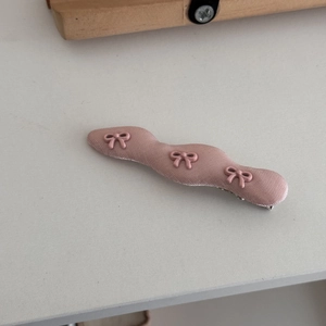 Detailansicht der rosa gewellten Haarklammer mit Satinstoff und drei kleinen Schleifen