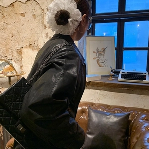 Stile retrò di un elastico per capelli in pizzo bianco abbinato a una borsa a tracolla