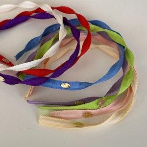 Close-up of colorful ribbed fabric headbands with elegant oval gold metal buckles