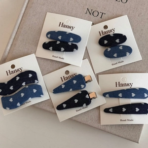 Detail view of denim hair clips with heart patterns on display cards