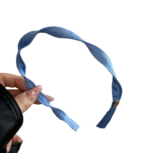 Light blue spiral fabric headband with wave edges and gold metal buckle detail