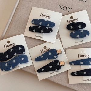 Detailed set of 10 denim hair clips with white heart prints on high-quality card packaging