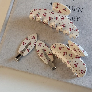 Vue détaillée du lot de 4 pinces à cheveux cerises avec strass et finition crème